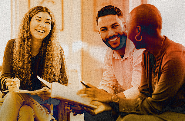 Three colleagues laughing together during a workshop