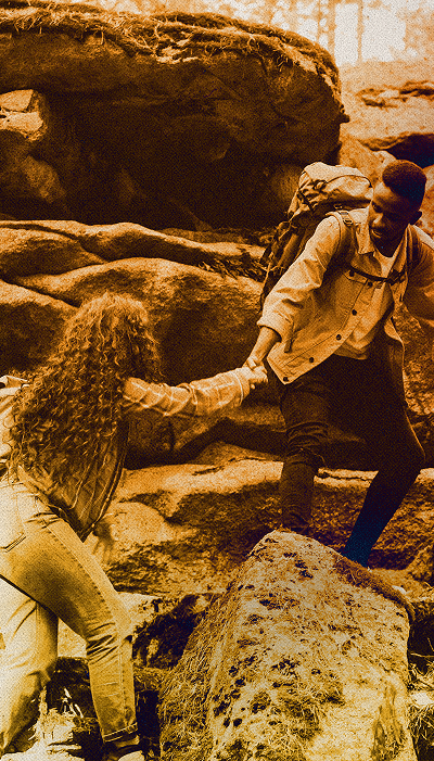 Climbers helping each other up rocks