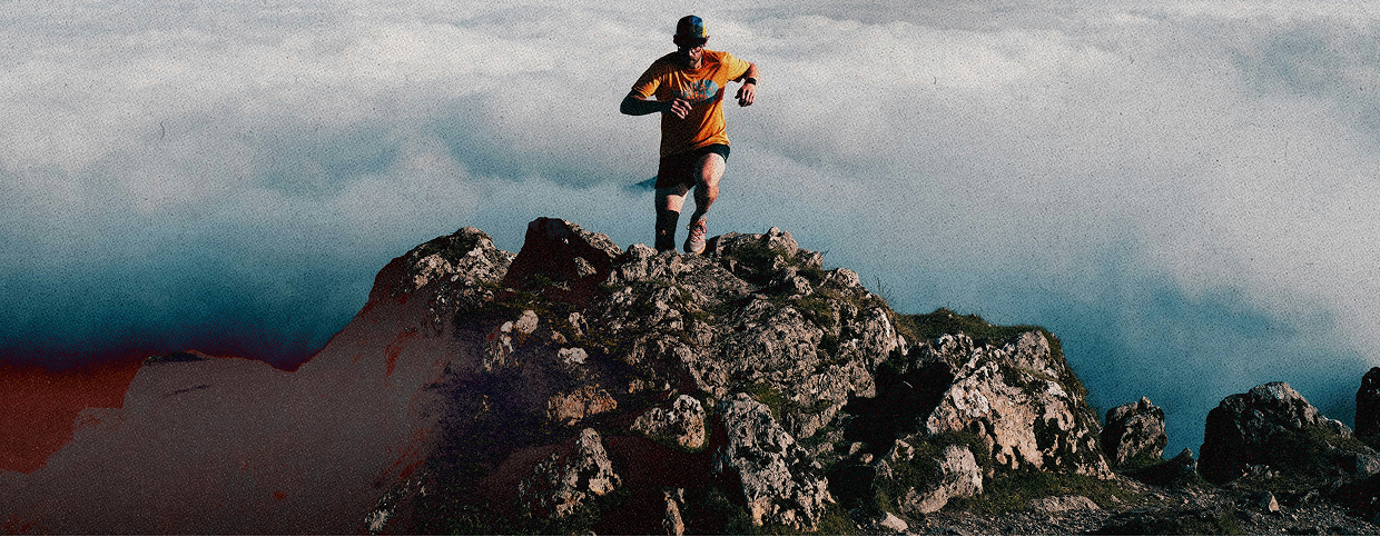 Runner on a mountain ridge above the clouds